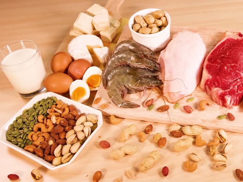 na stolu prikaz orašastog voća, kuvanih jaja, jogurta, škampa, piletine i govedine