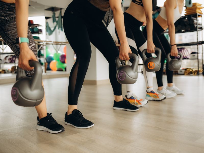 prikaz devojaka sa bučicama u rukama na grupnom treningu